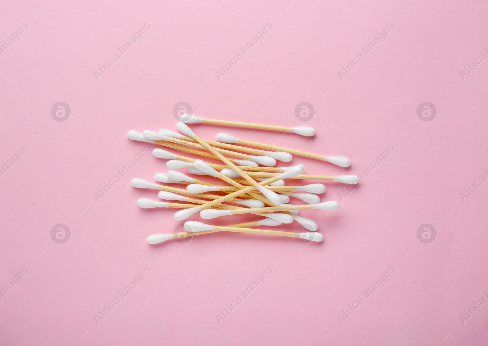 Photo of Heap of wooden cotton buds on pink background, flat lay