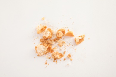 Photo of Scattered bread crumbs on white background, top view