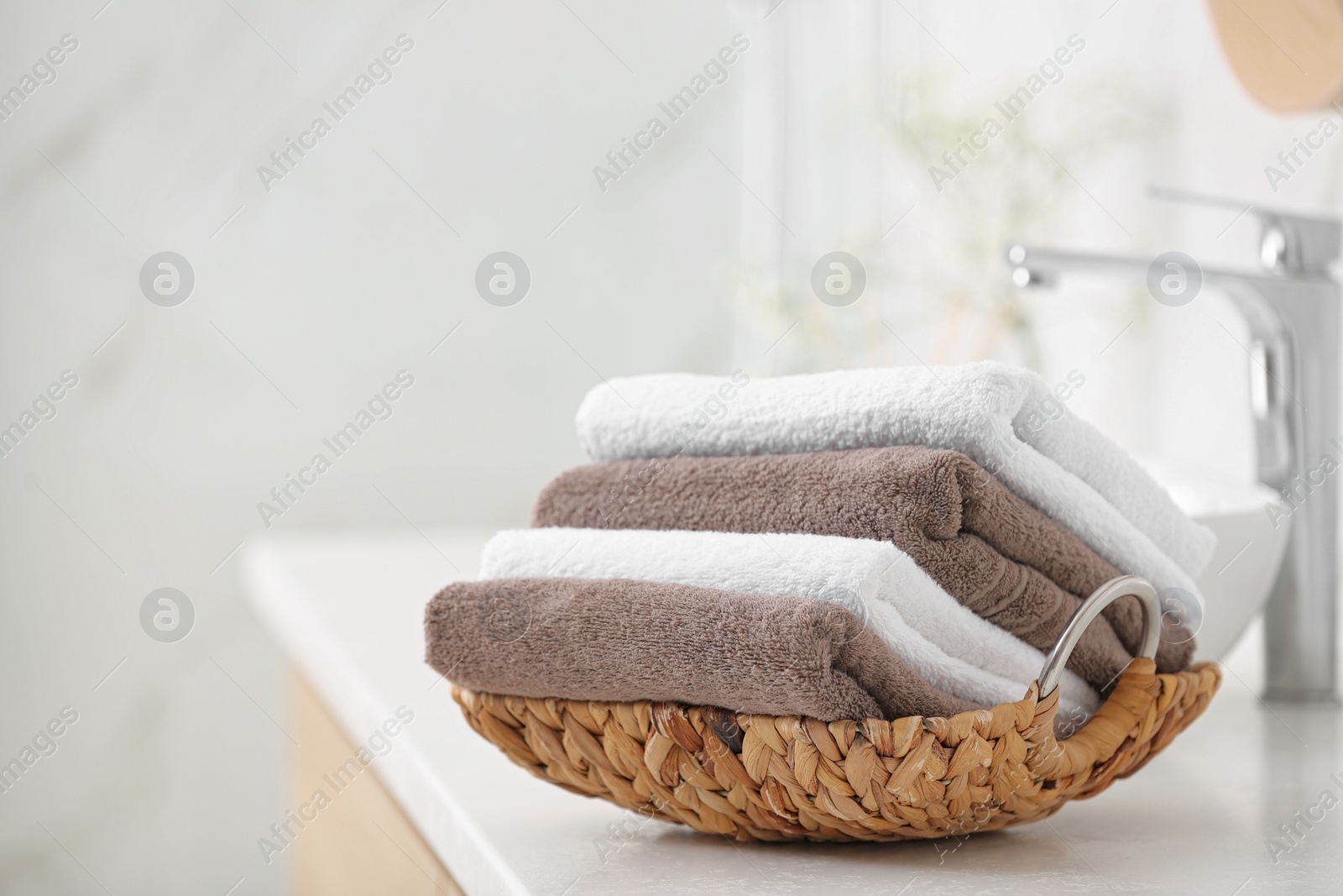 Photo of Basket with clean towels on counter in bathroom