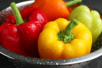 Photo of Colander with wet ripe bell peppers, closeup