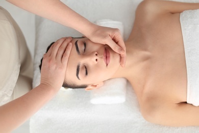 Photo of Young woman receiving massage in spa salon