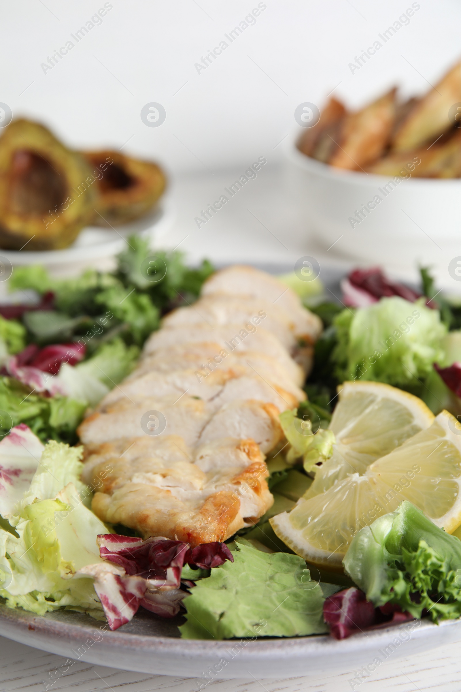 Photo of Tasty cooked chicken fillet with fresh salad served on white wooden table, closeup. Healthy meals from air fryer