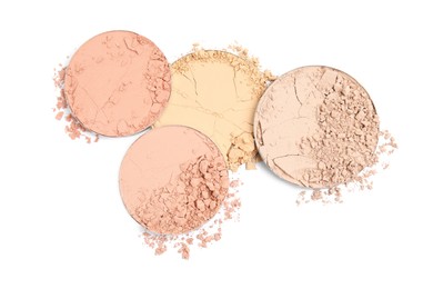 Photo of Different broken face powders on white background, top view