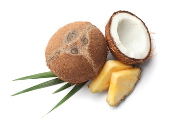 Tasty raw pineapple slices, coconut and leaves on white background, top view