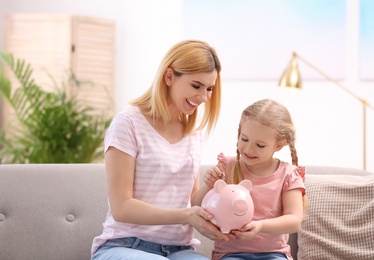 Family with piggy bank and money at home