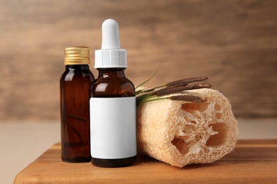 Photo of Bottles with cosmetic products, loofah sponge and reeds on wooden board, closeup