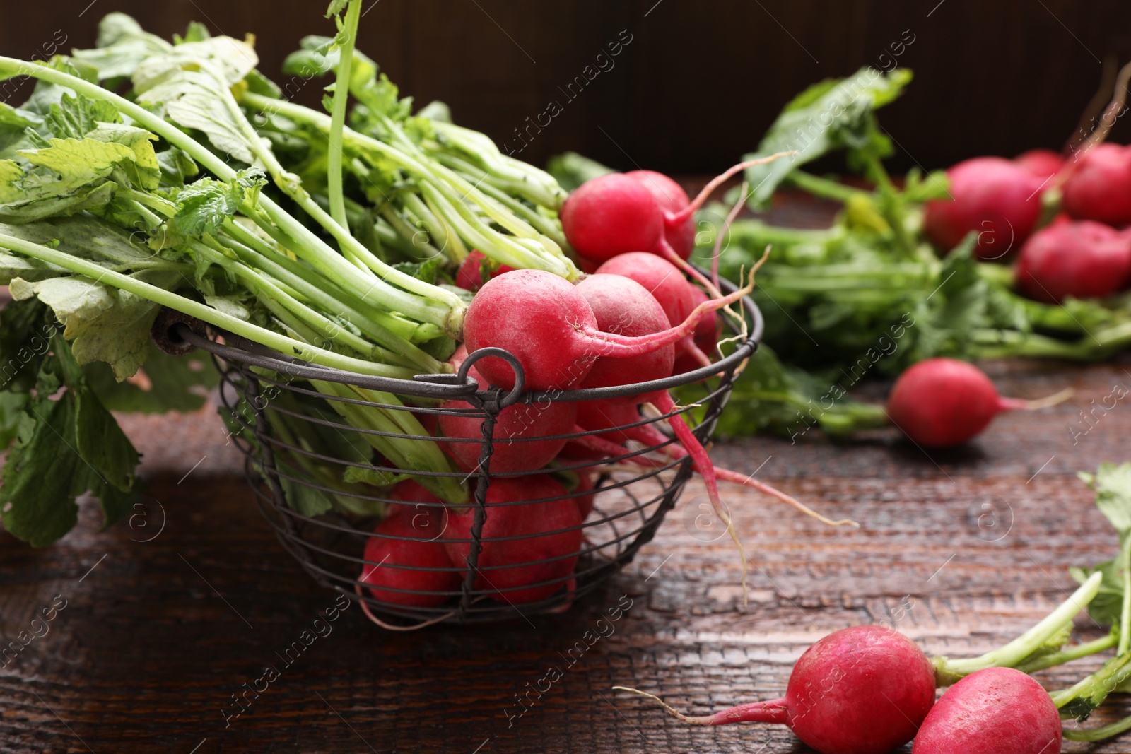 Photo of Basket with fresh ripe radish on wooden table