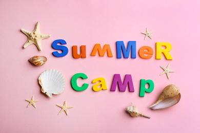 Photo of Flat lay composition with phrase SUMMER CAMP made of magnet letters on pink background