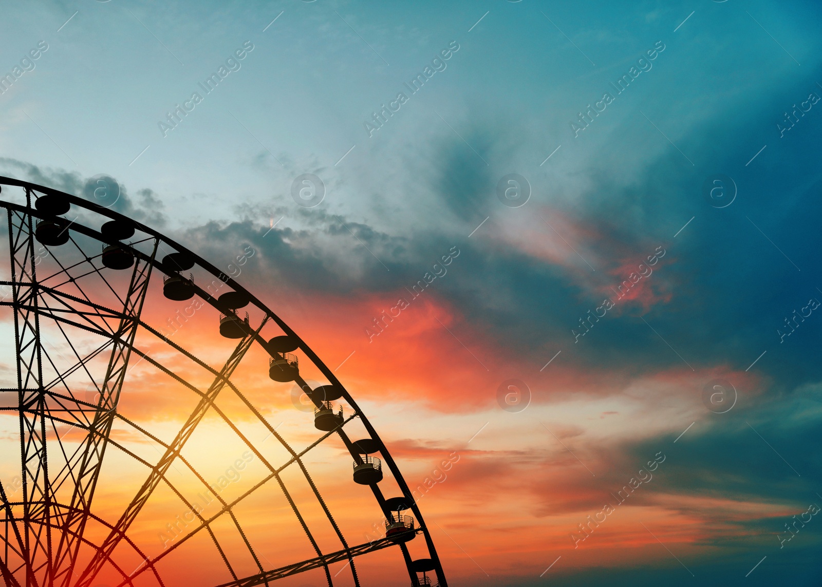 Image of Beautiful large Ferris wheel outdoors at sunset