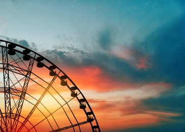 Beautiful large Ferris wheel outdoors at sunset