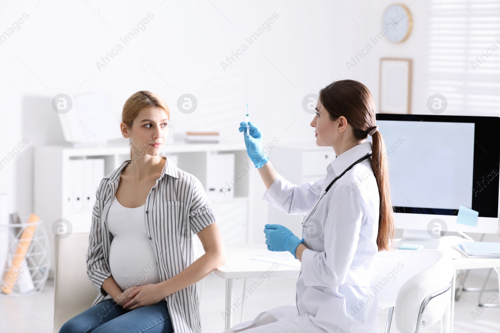 Photo of Doctor giving injection to pregnant woman in hospital. Vaccination concept