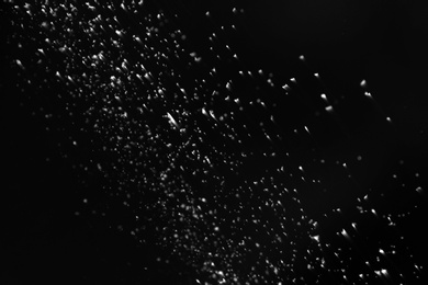 Photo of Snow flakes falling on black background. Winter weather