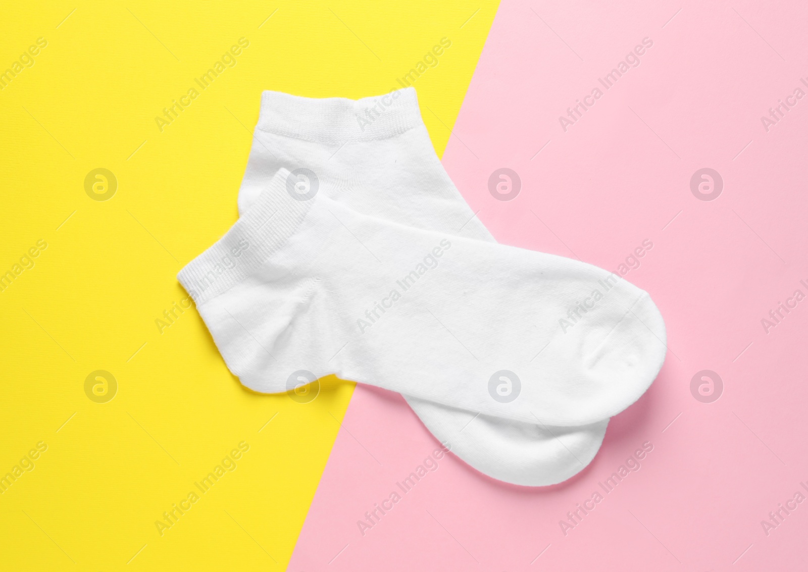 Photo of Pair of white socks on colorful background, flat lay