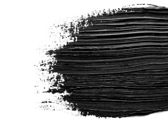 Brushstrokes of black oil paint on white background, top view