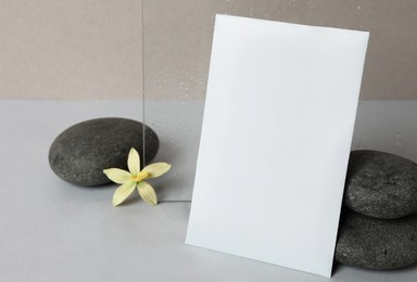 Scented sachet, spa stones and flower on grey table