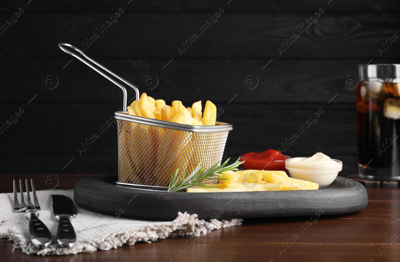 Photo of Tasty french fries and dip sauces served on wooden table