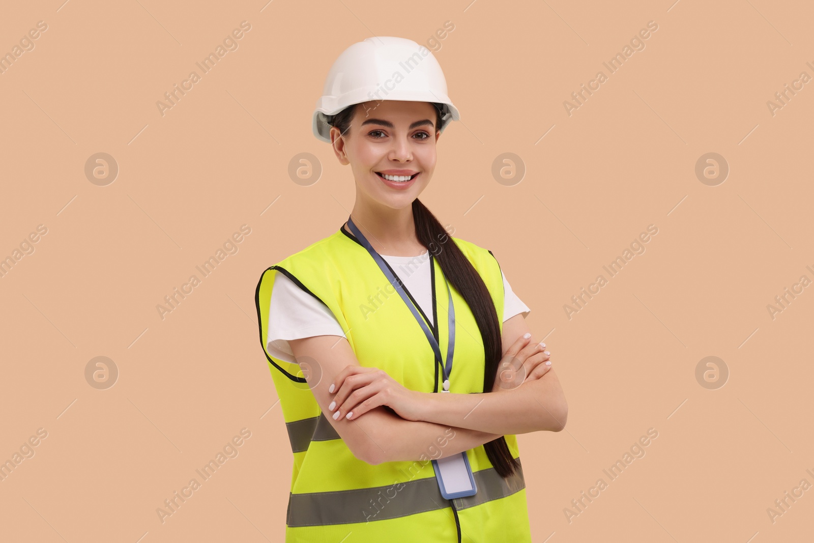 Photo of Engineer with hard hat and badge on beige background