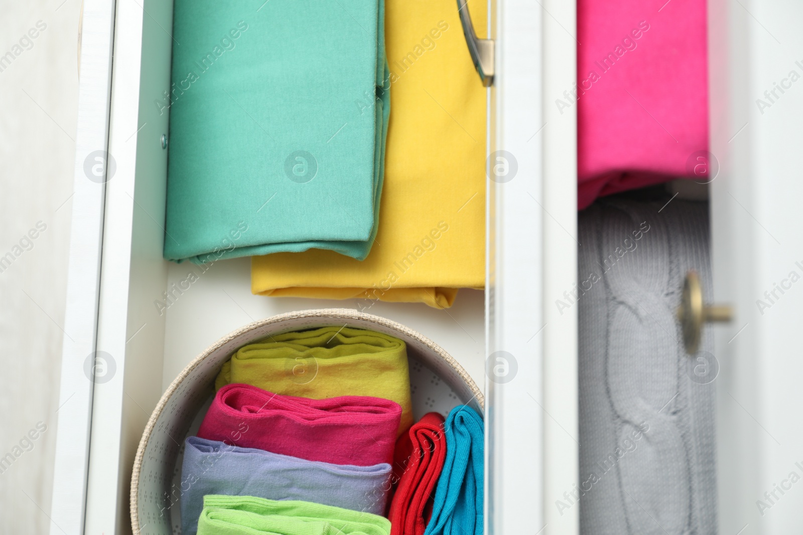 Photo of Chest of drawers with different folded clothes, top view