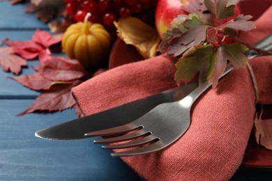 Photo of Festive table setting with autumn decor on blue wooden background, closeup