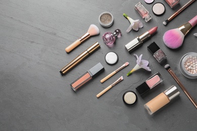 Photo of Many different makeup products and spring flowers on color background, flat lay. Space for text