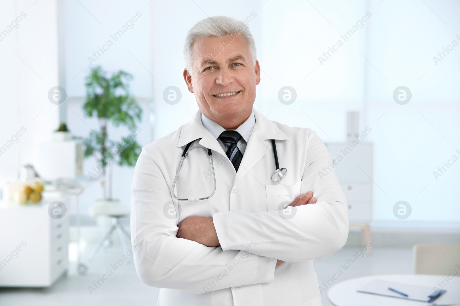 Photo of Portrait of male doctor in coat at workplace in clinic. Cardiology center