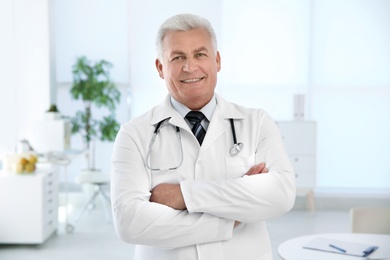 Portrait of male doctor in coat at workplace in clinic. Cardiology center