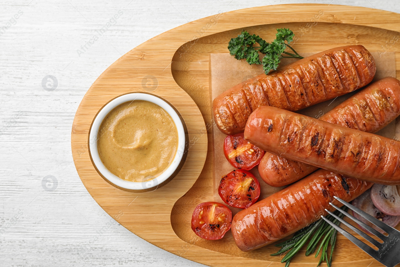 Photo of Delicious grilled sausages with sauce on wooden tray, top view. Barbecue food