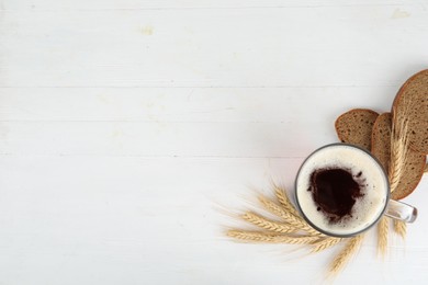 Photo of Flat lay composition with delicious kvass, spikes and bread on white wooden table. Space for text