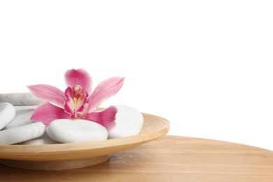 Photo of Wooden plate with orchid flower and spa rocks on table against white background. Space for text