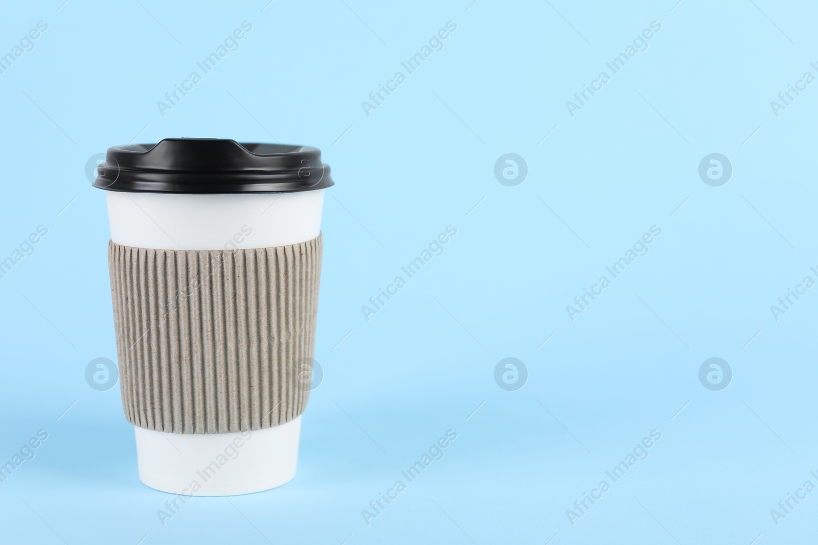 Photo of Paper cup with plastic lid on light blue background, space for text. Coffee to go