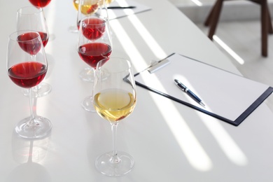 Photo of Glasses with delicious wine on table indoors