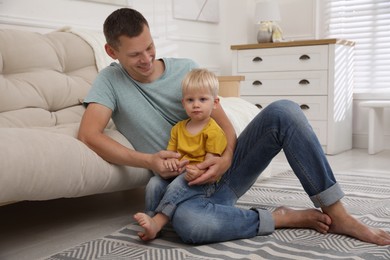 Photo of Father with his cute little son in living room