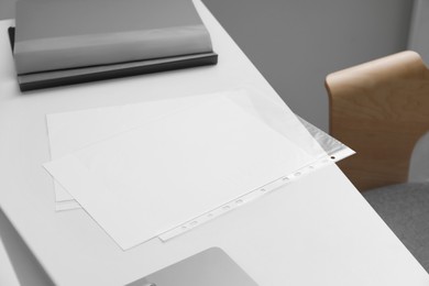 Photo of Punched pockets on white table in office