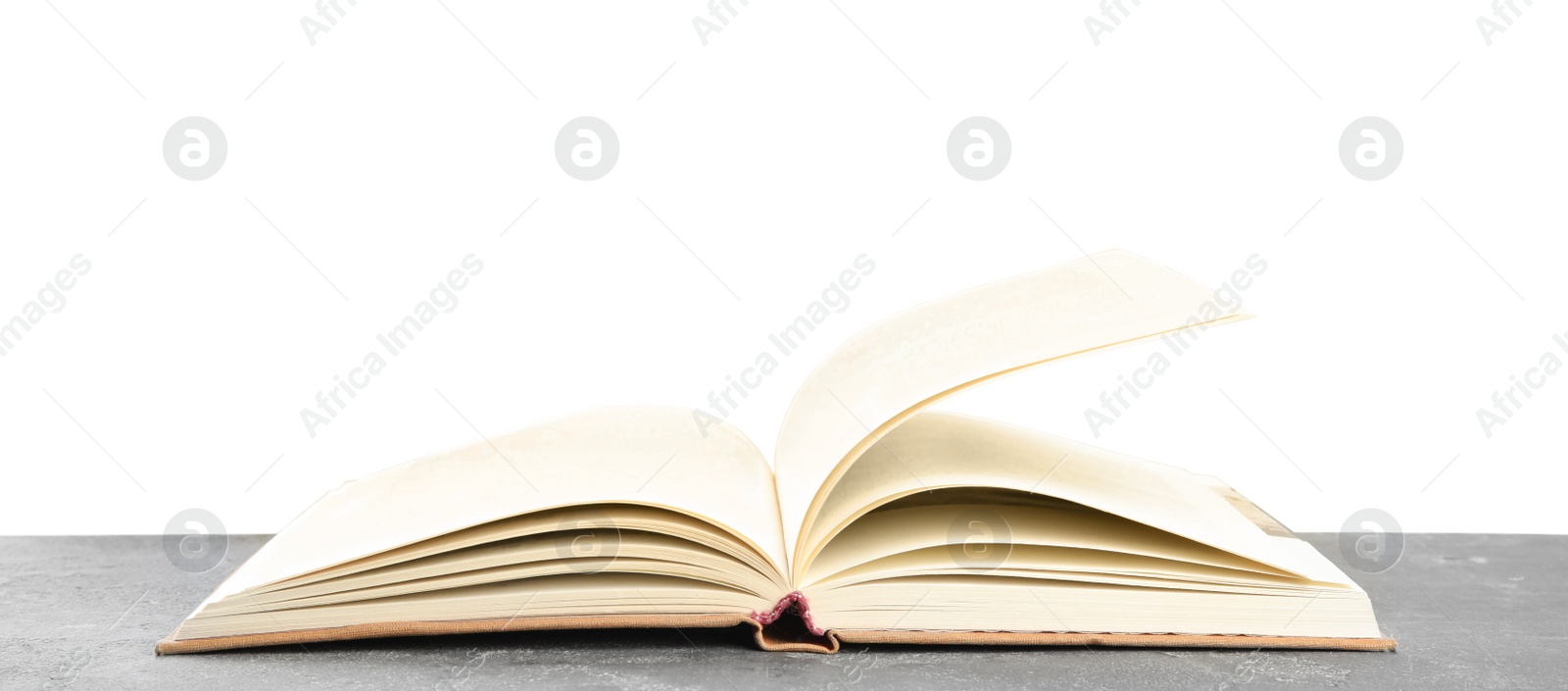 Photo of Open book on grey stone table against white background