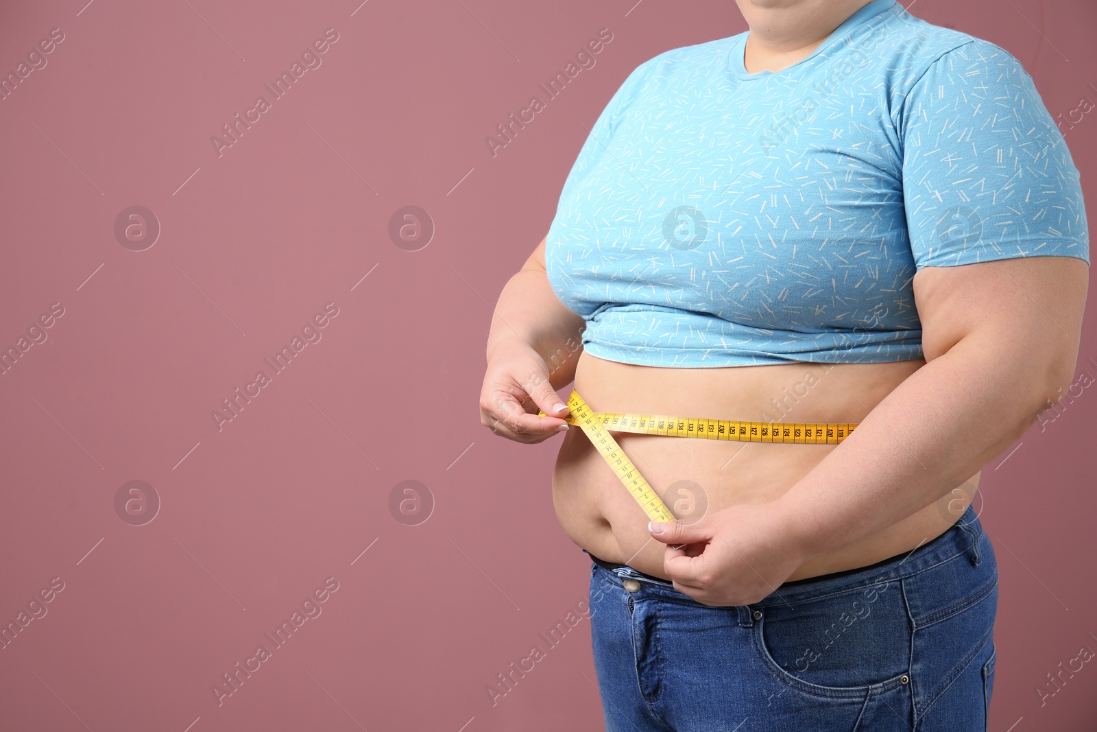 Photo of Overweight woman with measuring tape on color background