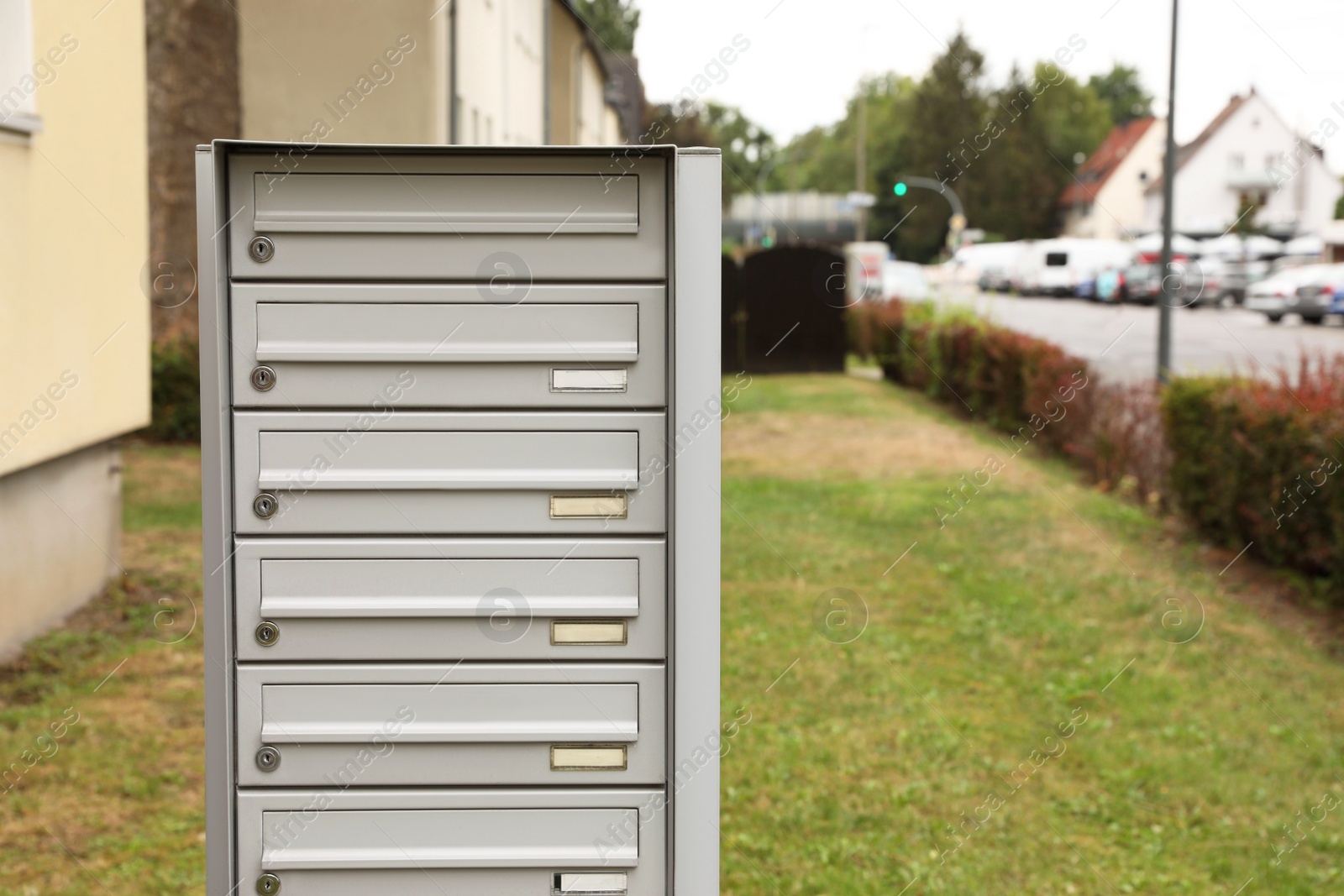 Photo of Metal letter boxes near apartment building outdoors. Space for text