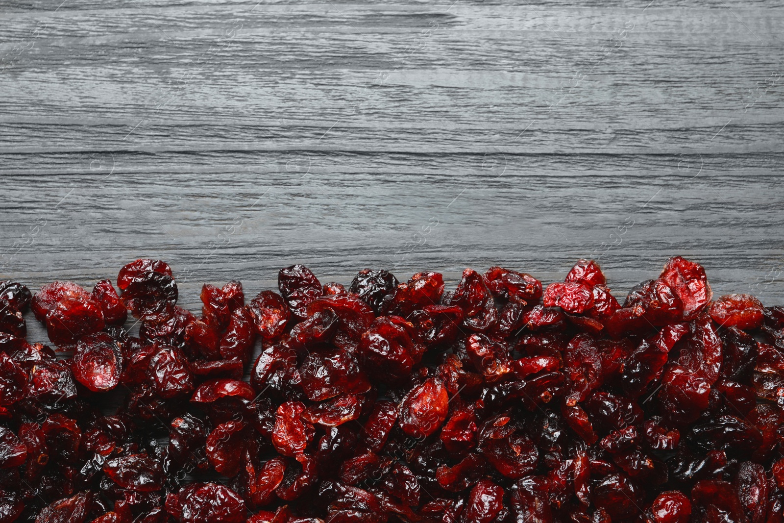 Photo of Tasty cranberries on wooden background, top view with space for text. Dried fruit as healthy snack