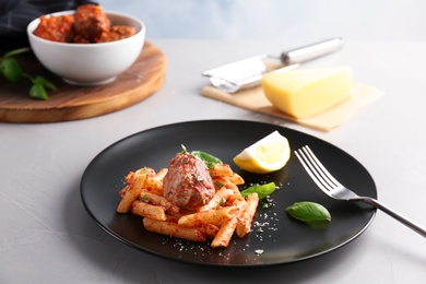 Delicious pasta with meatballs and tomato sauce on table