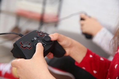 Photo of Children playing video game at home, closeup