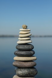 Photo of Stack of stones near sea on sunny day. Harmony and balance concept
