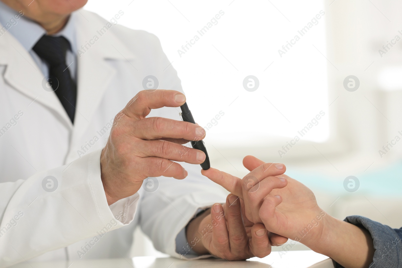 Photo of Doctor taking patient's blood sample with lancet pen in hospital, closeup. Diabetes control