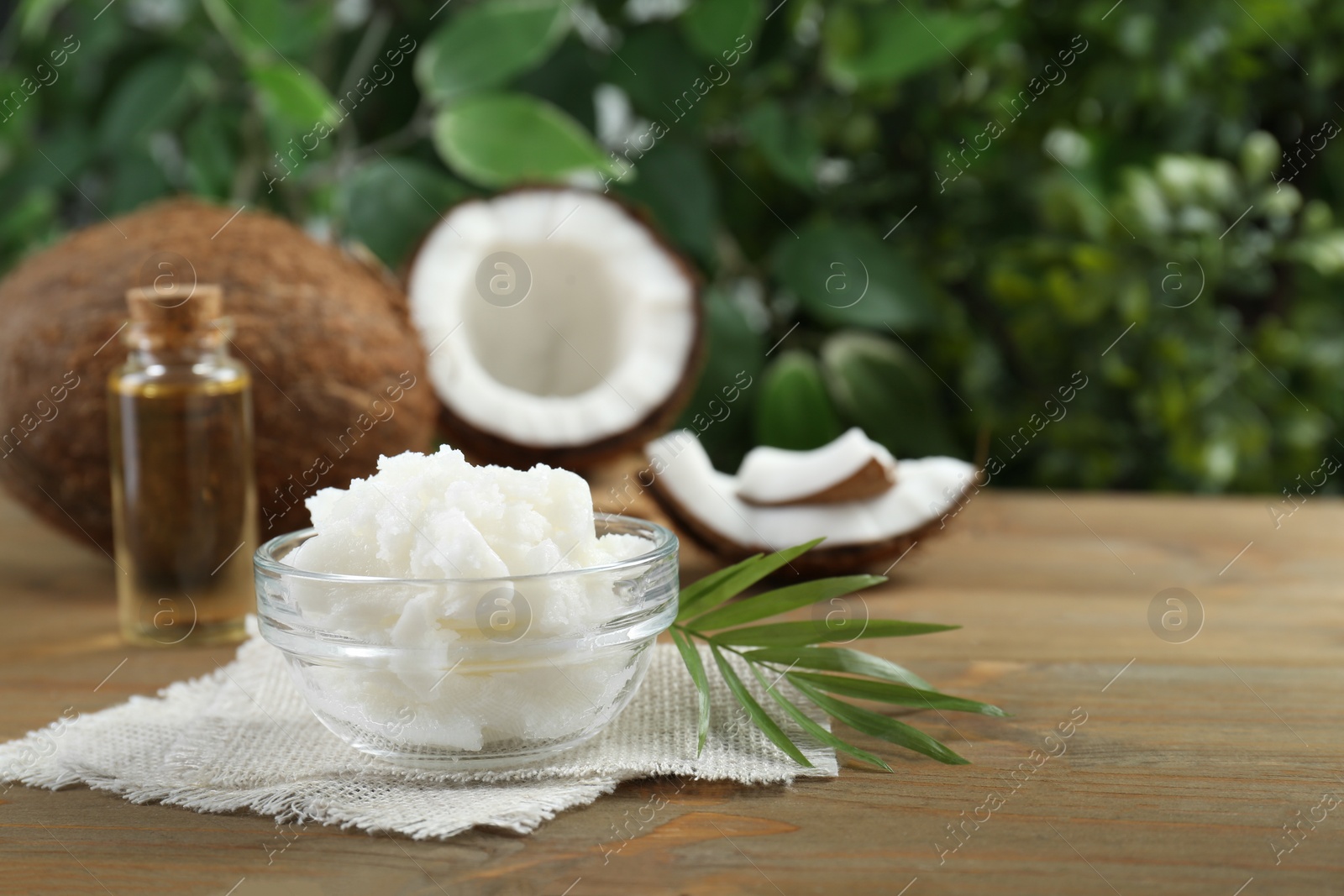 Photo of Organic coconut cooking oil on wooden table. Space for text