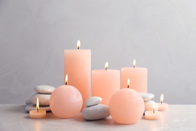 Beautiful composition with candles on table against grey background