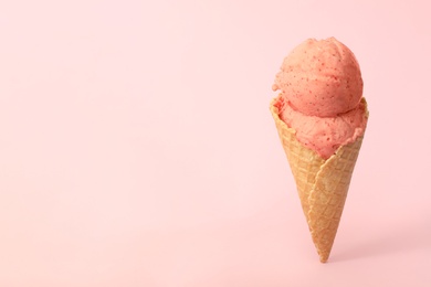 Delicious ice cream in waffle cone on pink background. Space for text