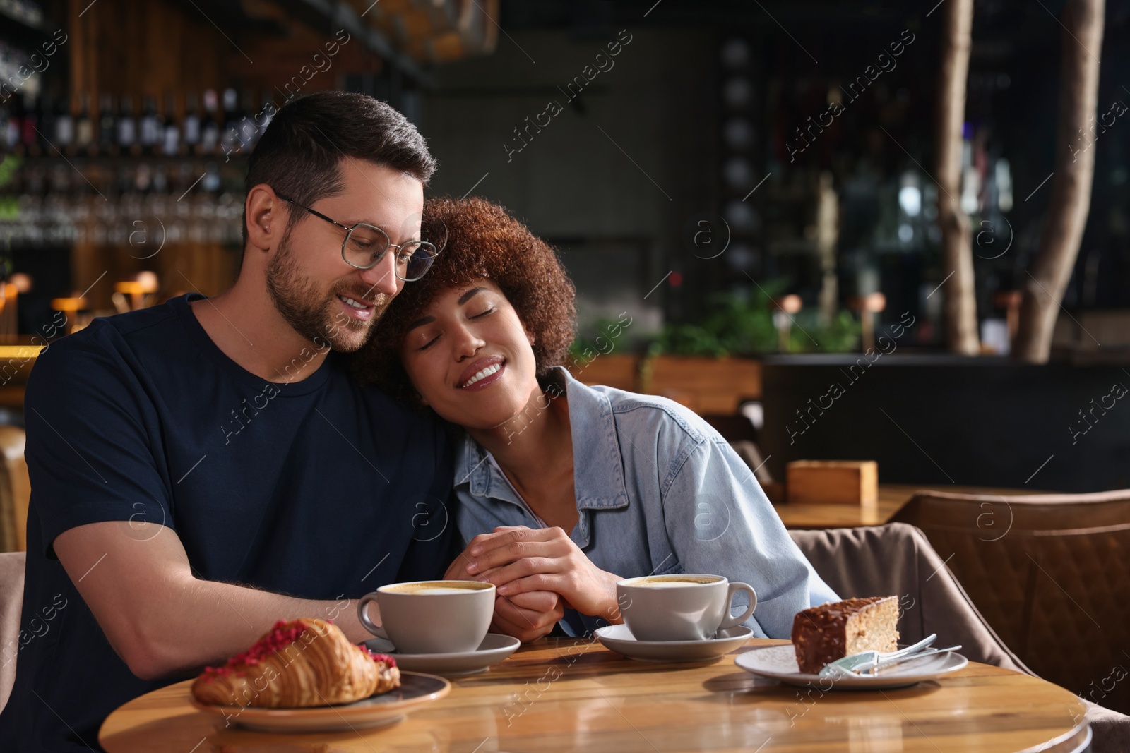 Photo of International dating. Lovely couple spending time together in cafe