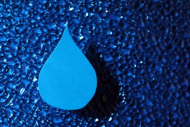 Photo of Water drop on blue surface, top view. Space for text