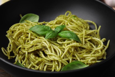 Photo of Delicious pasta with pesto sauce and basil in bowl, closeup