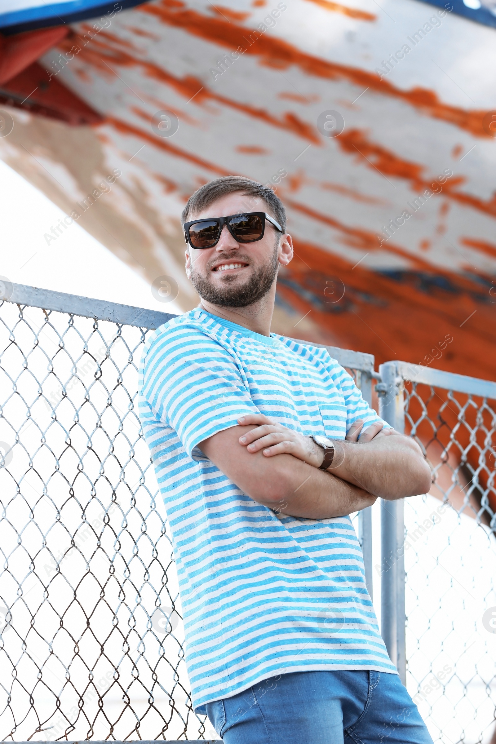 Photo of Young hipster man in stylish jeans on pier