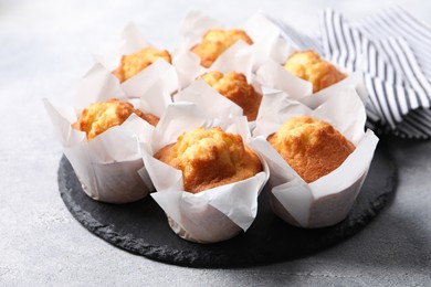 Delicious sweet muffins on light grey textured table, closeup