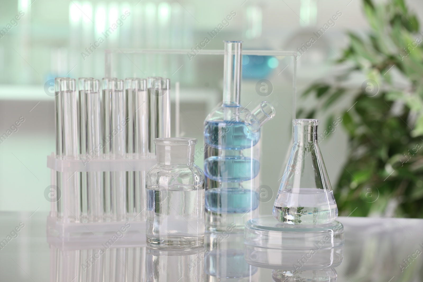 Photo of Laboratory analysis. Different glassware with liquid on white table indoors